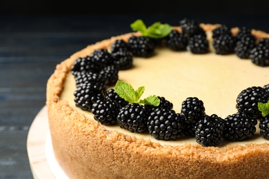 Delicious cheesecake decorated with blackberries on table