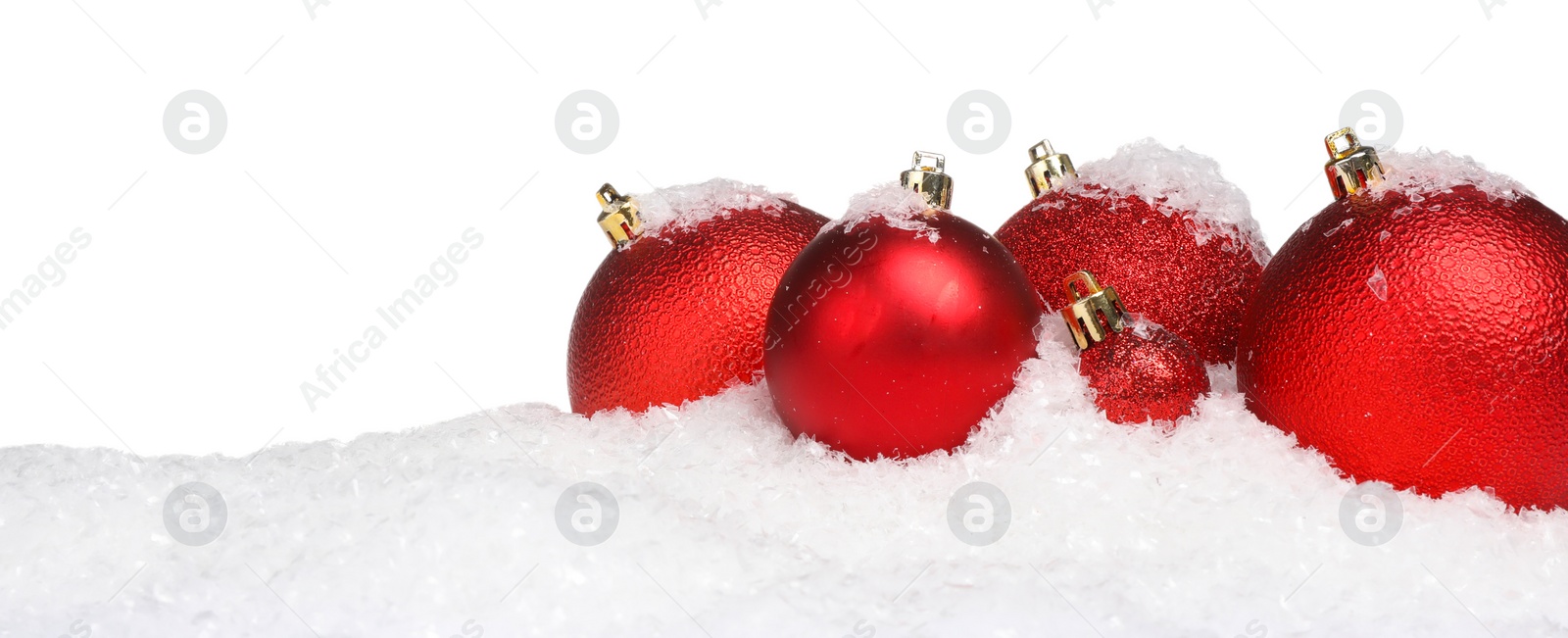 Photo of Beautiful red Christmas balls on snow against white background