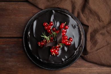 Photo of Tasty homemade chocolate cake with berries and rosemary on wooden table, flat lay