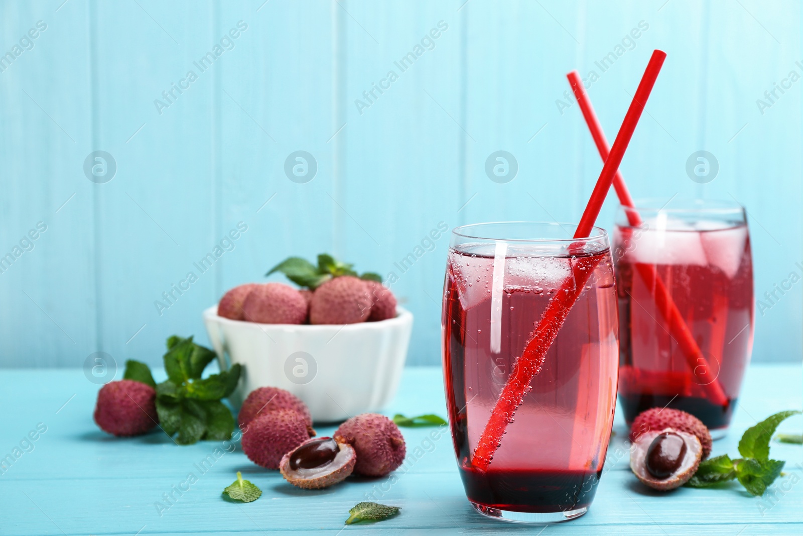 Photo of Lychee cocktail on cyan wooden table, space for text