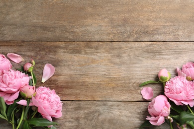 Photo of Beautiful fragrant peony flowers on wooden background