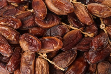 Sweet dried dates on branches as background, closeup. Healthy snack