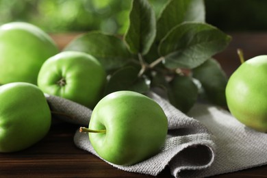 Photo of Fresh ripe green apples and leaves on wooden table outdoors, closeup