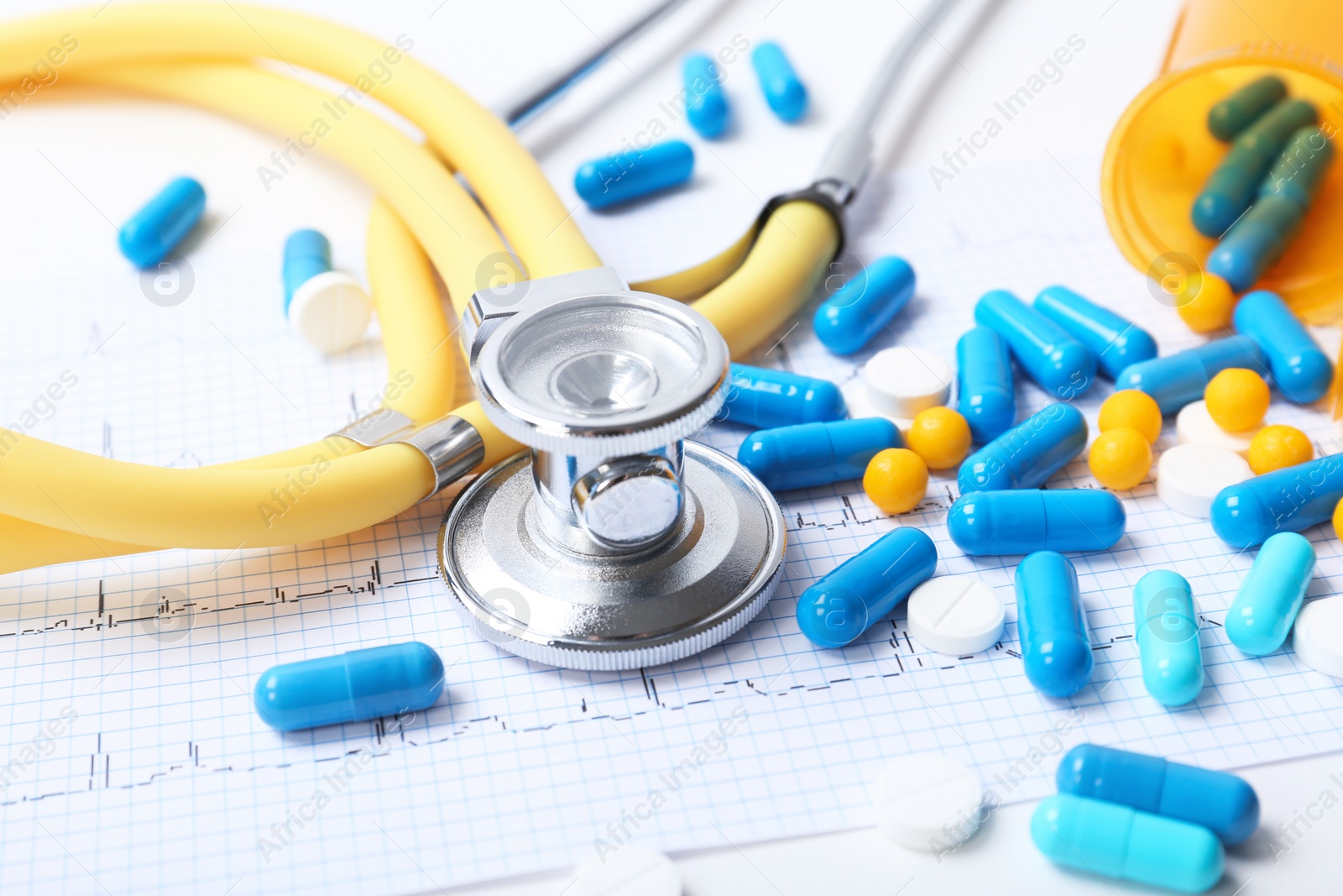 Photo of Stethoscope, cardiogram and pills on table. Cardiology service