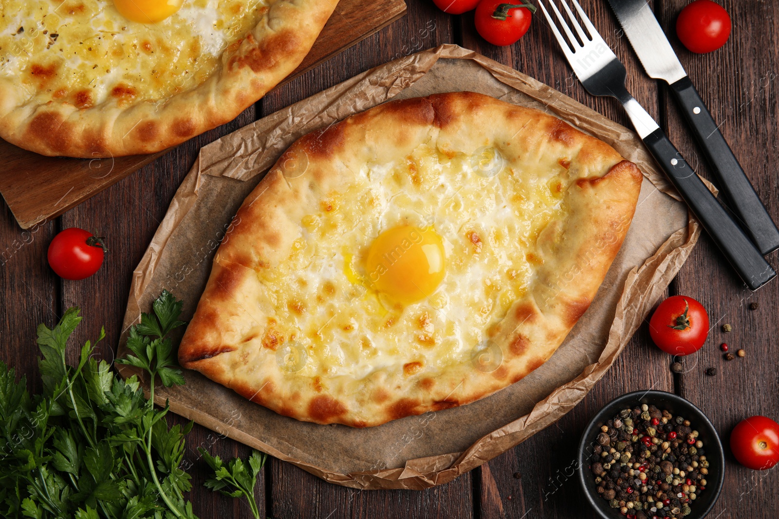 Photo of Fresh delicious Adjarian khachapuris served on wooden table, flat lay