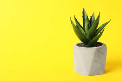 Photo of Beautiful artificial plant in flower pot on yellow background, space for text