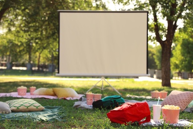 Photo of Empty open air cinema with blankets, pillows and popcorn. Space for text