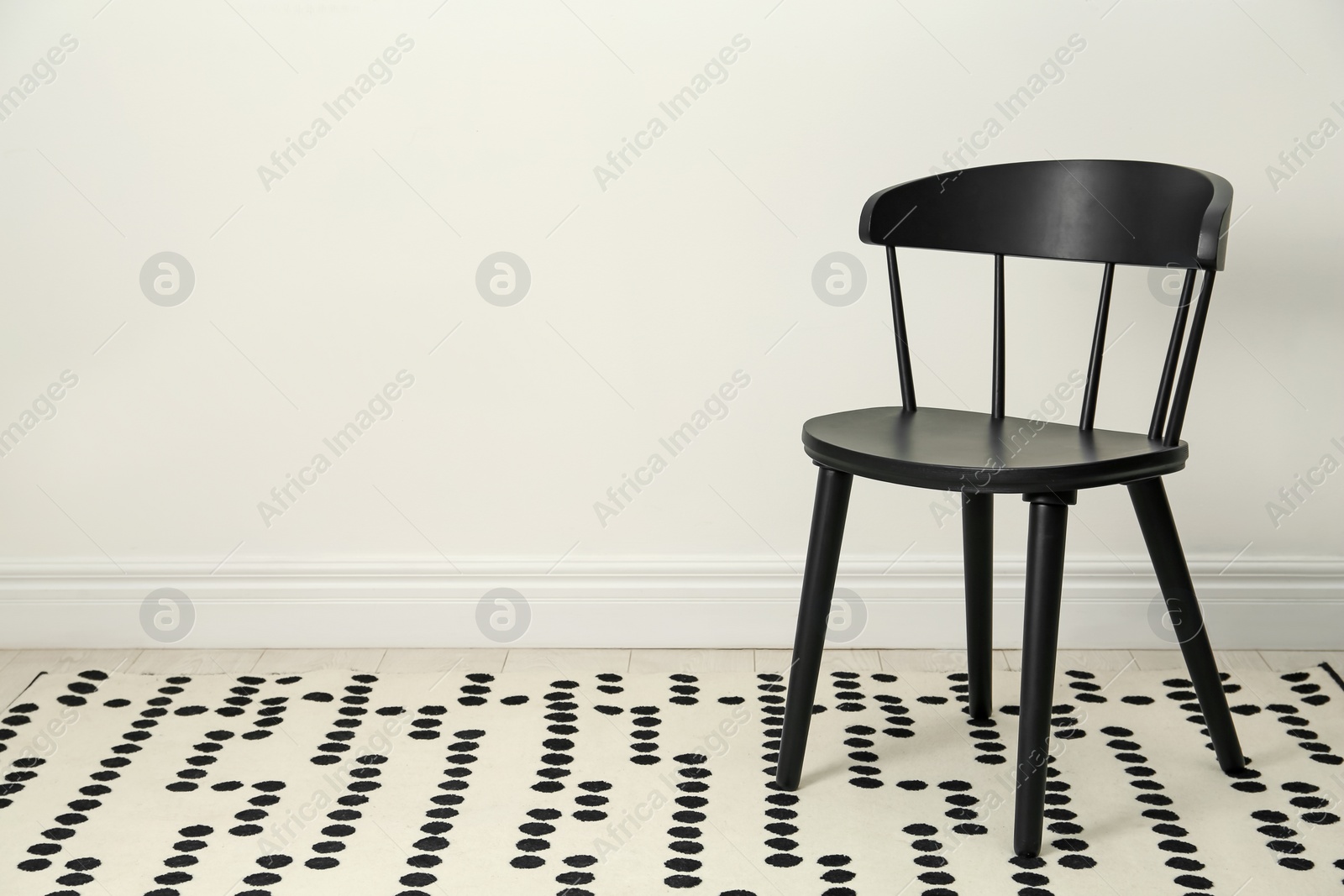 Photo of Stylish wooden chair near white wall indoors. Space for text