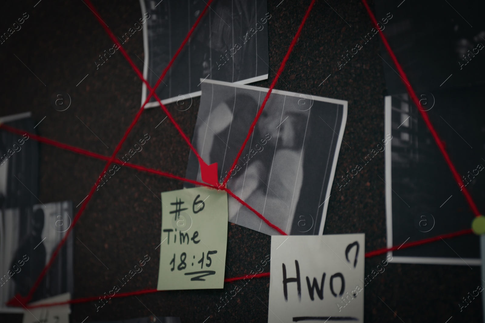 Photo of Detective board with crime scene photos, stickers, clues and red thread, closeup