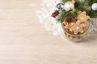 Tasty Christmas cookies and festive decor on beige wooden table, above view. Space for text