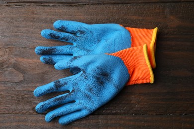 Photo of Pair of color gardening gloves on wooden table, top view