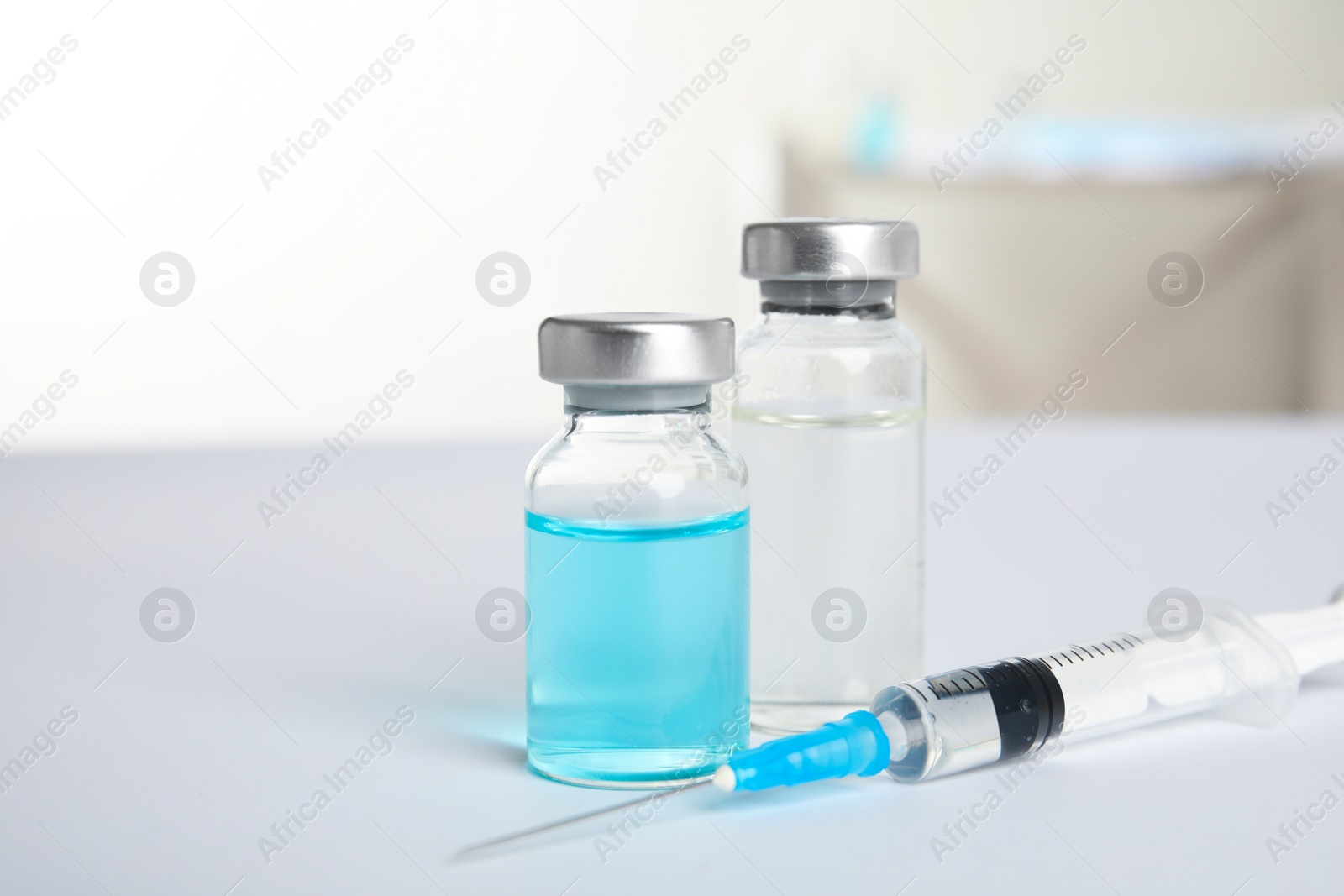 Photo of Vials and syringe on light background. Vaccination and immunization