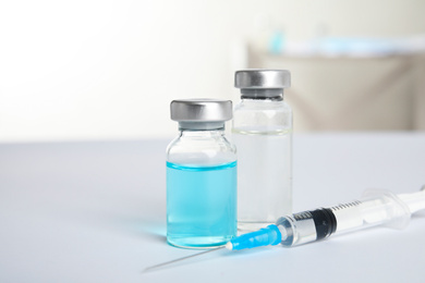 Vials and syringe on light background. Vaccination and immunization