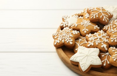 Tasty Christmas cookies with icing on white wooden table. Space for text