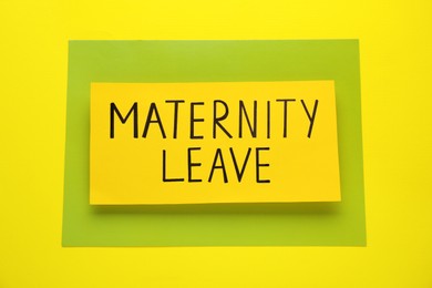 Photo of Note with words Maternity Leave on yellow background, top view