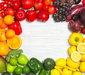 Photo of Rainbow frame made of fresh fruits and vegetables on wooden background