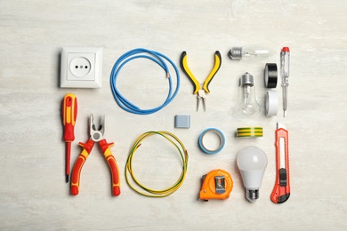 Flat lay composition with electrician's tools on light background