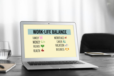 Image of Work-life balance concept. Modern laptop on wooden table in office