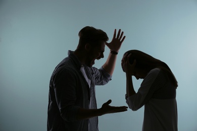 Photo of Silhouette of couple having argument on color background. Relationship problems