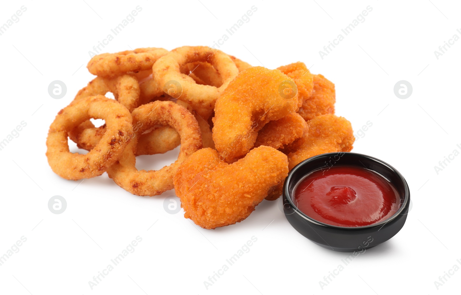 Photo of Tasty fried onion rings, chicken nuggets and ketchup on white background