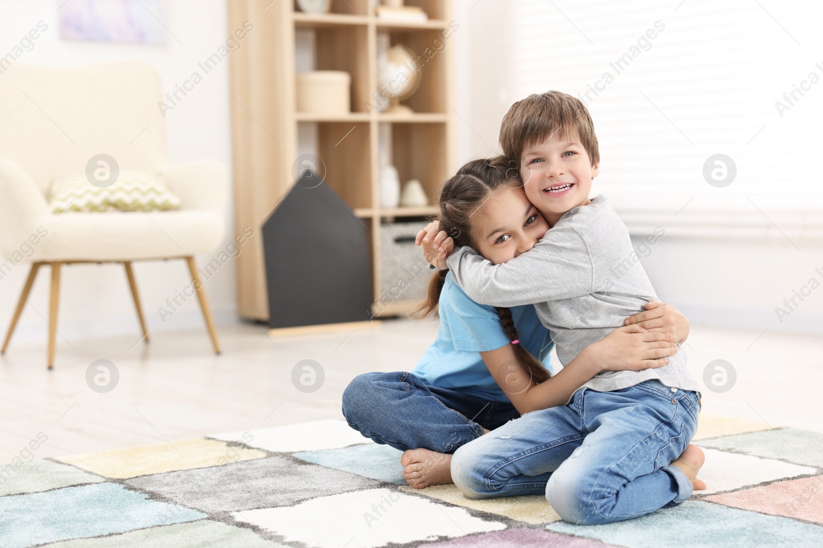 Photo of Happy brother and sister hugging together at home, space for text