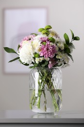 Photo of Bouquet of beautiful chrysanthemum flowers on table in room