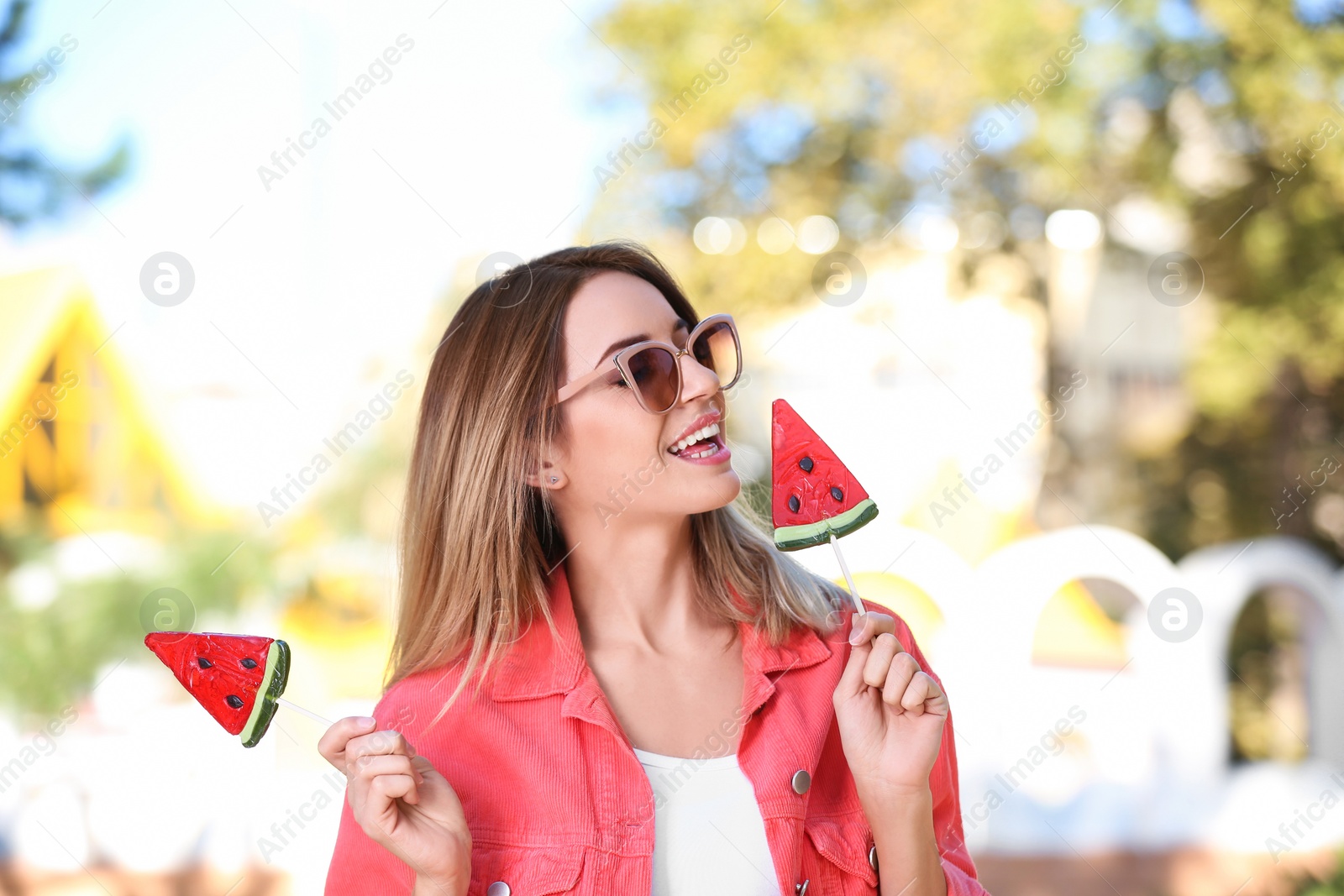 Photo of Young happy woman with sweet candies outdoors