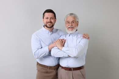 Happy son and his dad on gray background