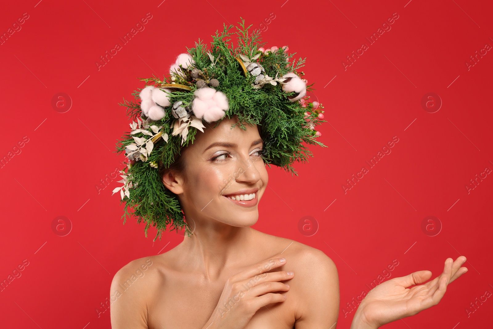 Photo of Happy young woman wearing wreath on red background