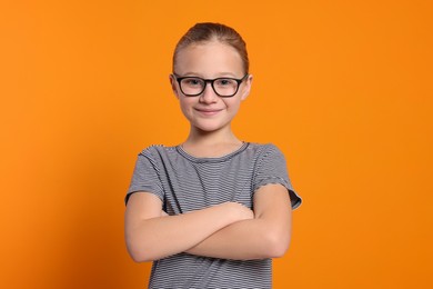 Photo of Portrait of cute girl in glasses on orange background