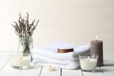 Photo of Beautiful composition with burning candles and different spa products on white wooden table