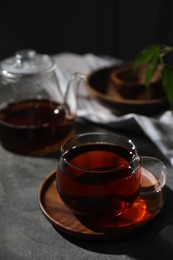 Photo of Tasty hot tea in cup on grey table, closeup