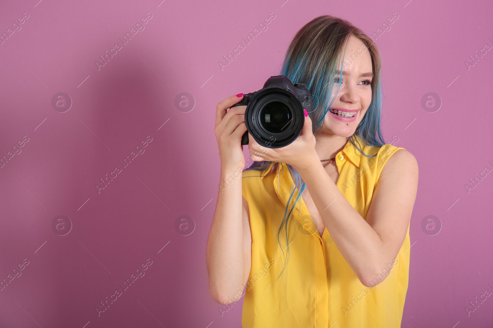 Photo of Young female photographer with camera on color background