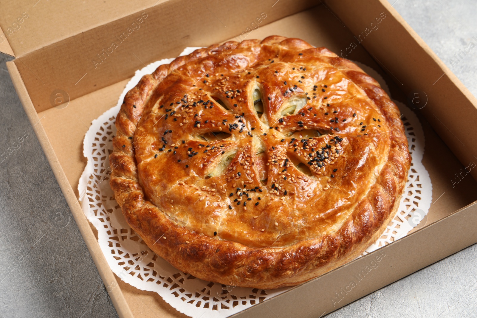 Photo of Tasty homemade pie in box on light table