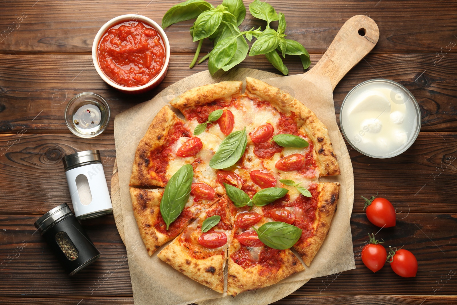 Photo of Delicious Margherita pizza and ingredients on wooden table, top view