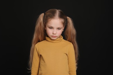 Photo of Little girl on black background. Children's bullying