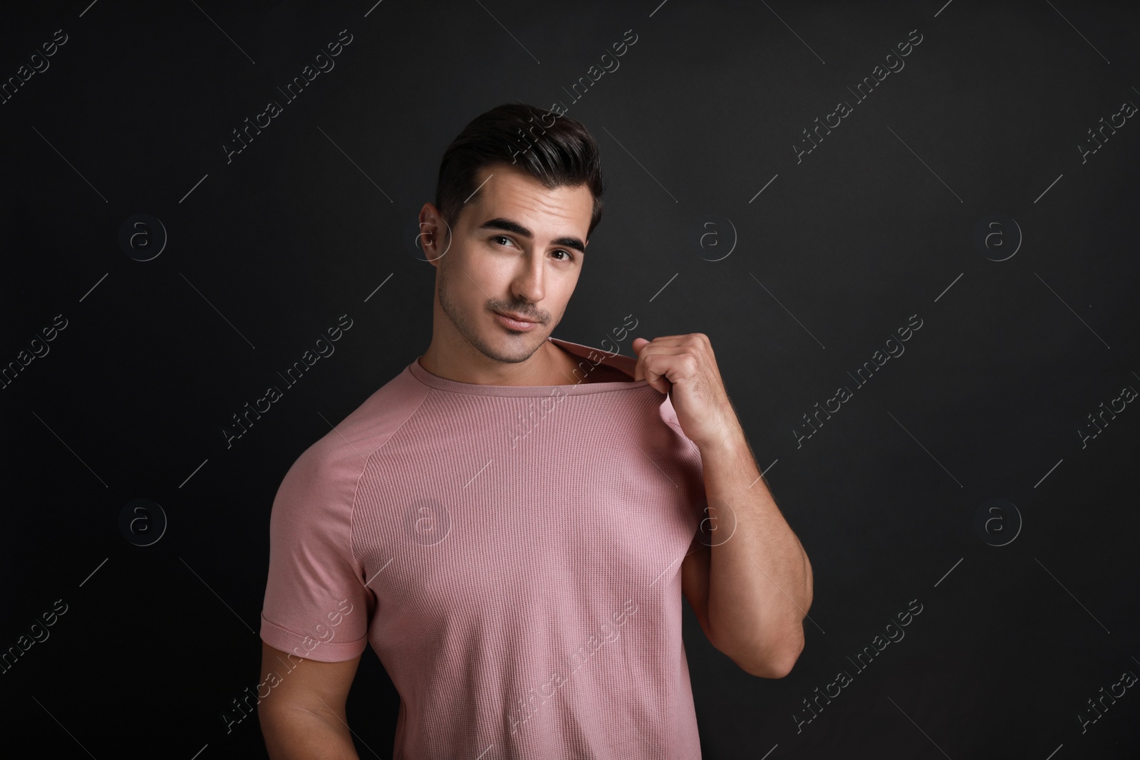 Photo of Portrait of handsome young man on black background