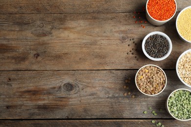 Photo of Flat lay composition with different types of legumes and cereals on wooden table, space for text. Organic grains