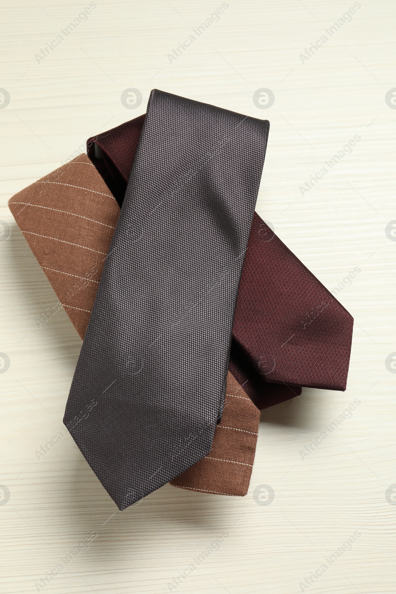 Photo of Different neckties on white wooden table, top view