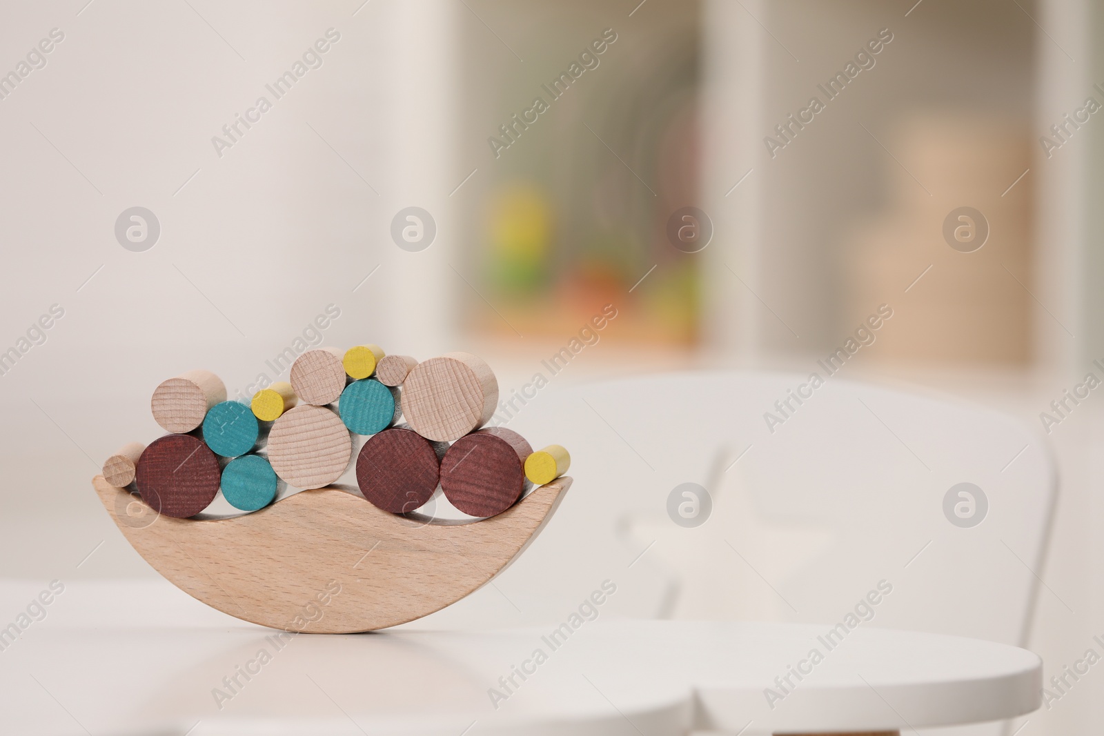 Photo of Wooden pieces of balancing game on white table indoors, space for text. Educational toy for motor skills development