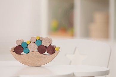 Wooden pieces of balancing game on white table indoors, space for text. Educational toy for motor skills development