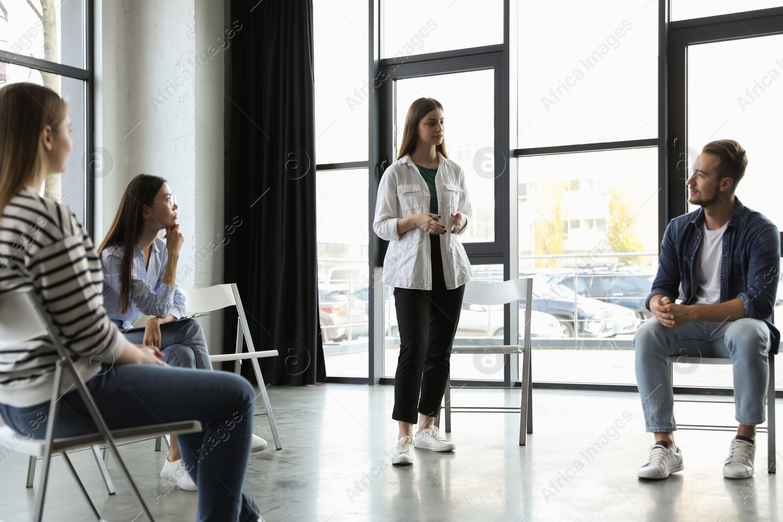 Photo of Psychotherapist working with patients in group therapy session indoors