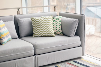 Photo of Interior of modern living room with cushions on sofa