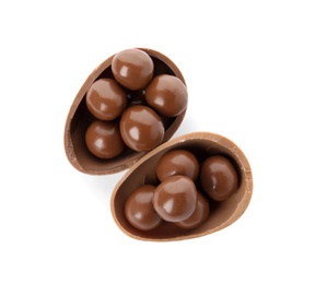 Photo of Halves of tasty chocolate egg with candies on white background, top view