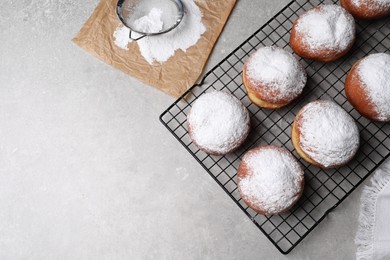 Photo of Delicious sweet buns and strainer with powdered sugar on gray table, flat lay. Space for text