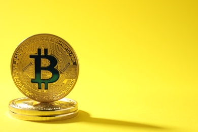 Golden bitcoins on color background, space for text. Digital currency