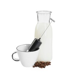 Photo of Mini mixer (milk frother), cup, coffee beans and bottle isolated on white