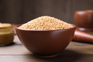 Mustard seeds in bowl on wooden table