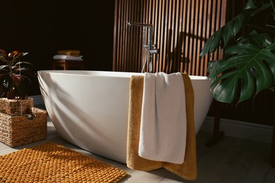 Photo of Cozy bathroom interior with stylish ceramic tub