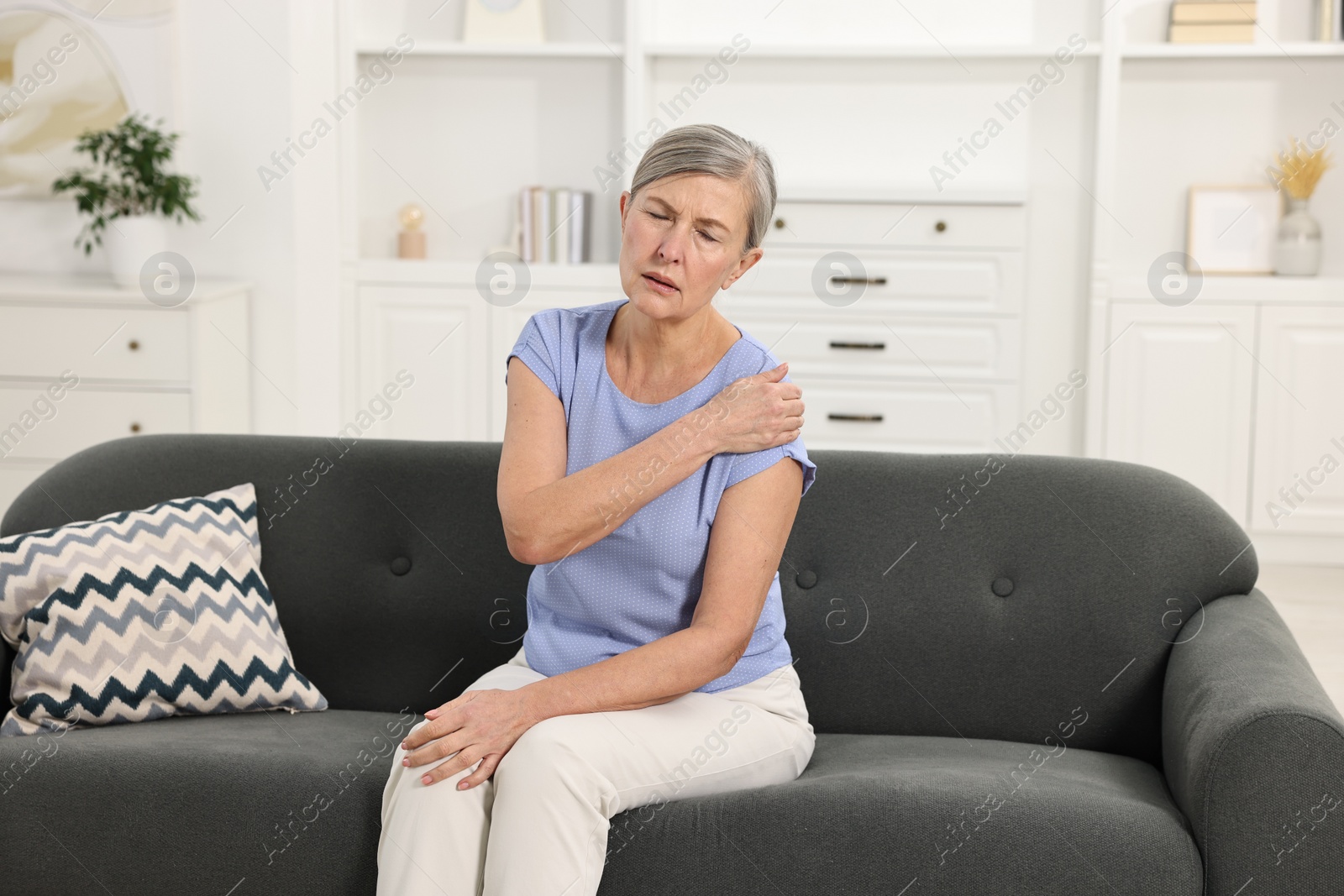 Photo of Arthritis symptoms. Woman suffering from pain in shoulder at home